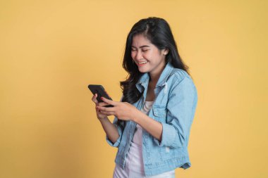 Genç Asyalı kadın cep telefonu kullanıyor SMS mesajı yazıyor