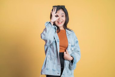 Genç bir kadın dürbünü taklit eden bakışlar atıyor.