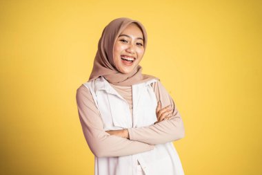 Müslüman kadın ellerini çapraz yapıp izole bir şekilde duruyor.