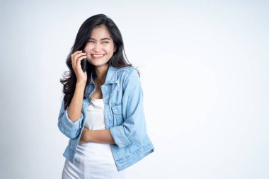 Genç bir kadın cep telefonuyla arama yapıyor.