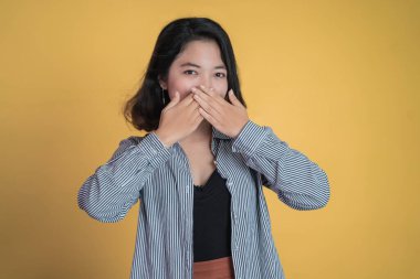 Ağzını kapatan elleri ile şok olmuş genç bir kadın.