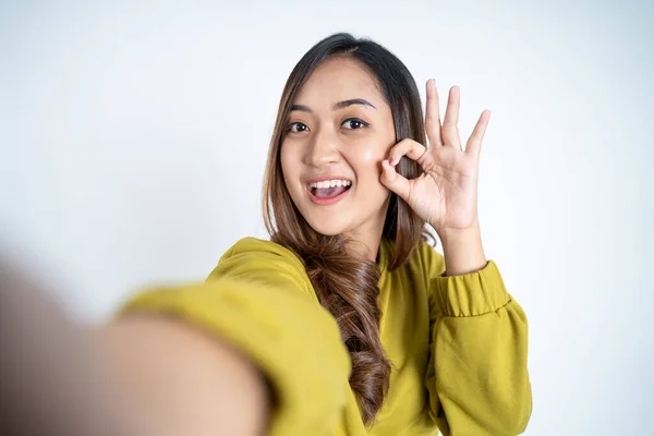 Sorrindo asiático mulher tomar um selfie com ok mãos gesto — Fotografia de Stock