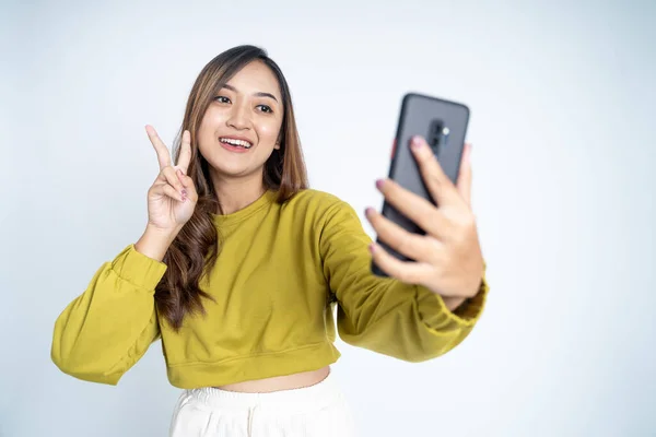 Jonge vrouw nemen een selfie met vrede handen gebaar — Stockfoto