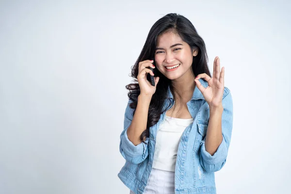 Молодая женщина делает звонок с хорошо жестом рукой — стоковое фото