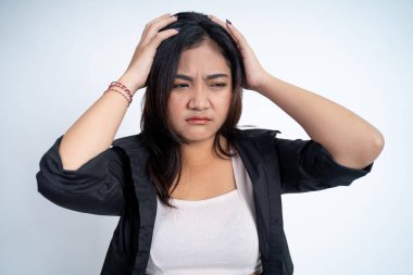 Kafası karışık genç bir kadın başını tutuyor.