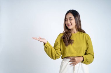 El hareketi yapan Asyalı bir kız izole bir arka planda bir şey sunuyor.