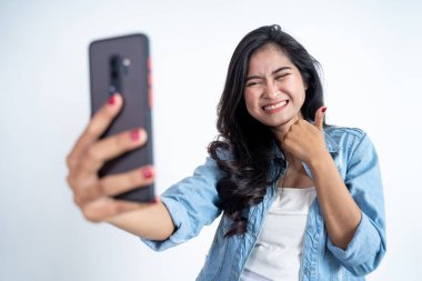 Genç bir kadın başparmaklarıyla bir video görüşmesi yapıyor.