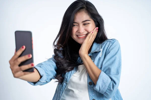 Jonge vrouw maken een video gesprek met behulp van mobiele telefoon op geïsoleerde achtergrond — Stockfoto