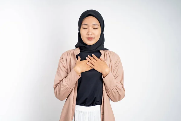 Mulher muçulmana fechar os olhos segurando peito enquanto se sente aliviado — Fotografia de Stock