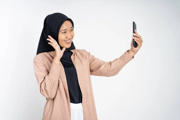 Woman in hijab holding a smart phone for selfie — Stock Photo, Image