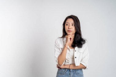 Asyalı kadın bir şey düşünüyor ve yukarı bakıyor.