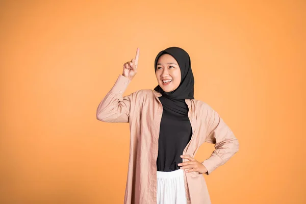 Sorrindo mulher hijab com o dedo apontando para cima gesto da mão — Fotografia de Stock
