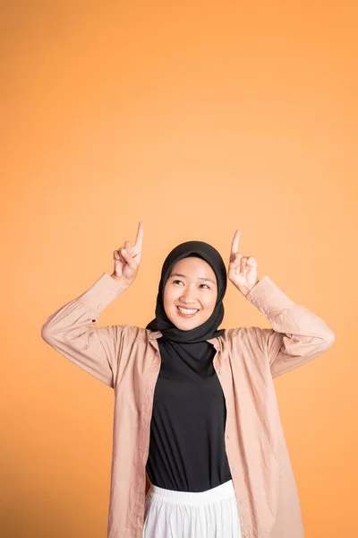 Sorrindo mulher hijab com o dedo apontando para cima gesto da mão — Fotografia de Stock
