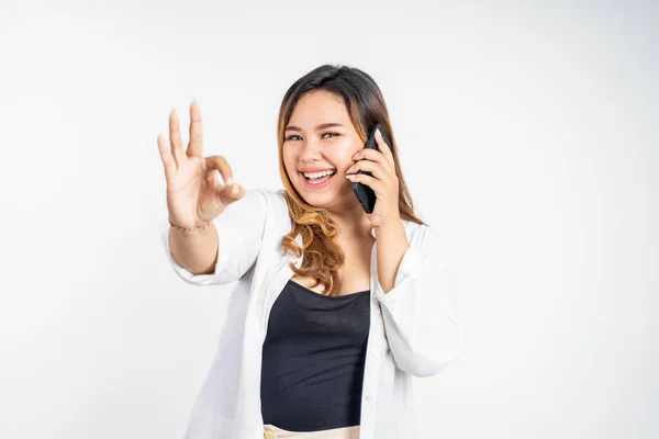 Mulher fazendo uma chamada usando telefone com gesto ok — Fotografia de Stock