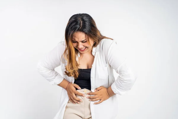 Giovane donna asiatica nel dolore con entrambe le mani tenendo lo stomaco — Foto Stock