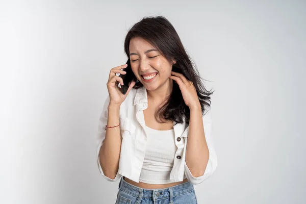 Lycklig asiatisk kvinna ringer ett samtal med hjälp av en mobiltelefon — Stockfoto
