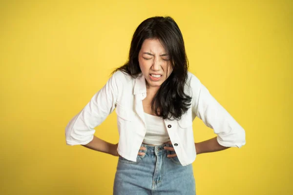 Jovem mulher asiática na dor com ambas as mãos segurando estômago — Fotografia de Stock
