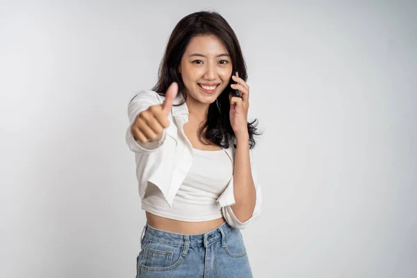Жінка робить дзвінок за допомогою мобільного телефону з великими пальцями вгору — стокове фото