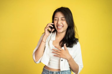 Mutlu Asyalı kadın cep telefonuyla arama yapıyor.