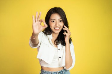 Bir kadın iyi bir jestle telefonla arama yapıyor.