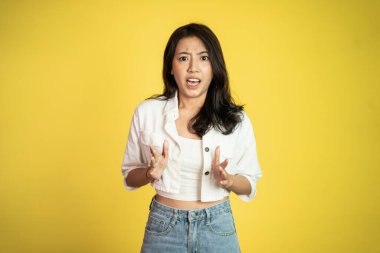 Asyalı kadın, izole edilmiş arka planda şok olmuş ve şaşırmış hissediyor