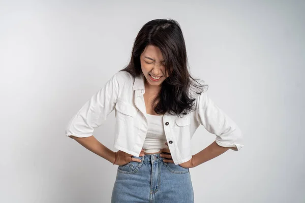 Joven asiático mujer en dolor con ambos manos celebración estómago —  Fotos de Stock