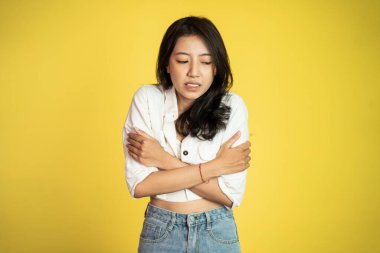 Kadın üşümüş, iki eli de kollarında.