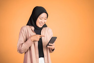 Müslüman kadın telefonuna gülüyor, sarıda izole bir şekilde.