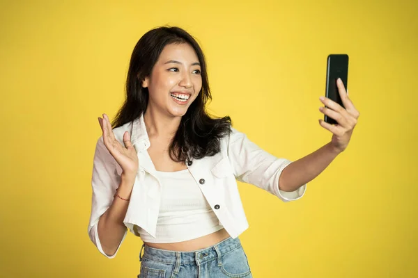 アジアの女性は、セルフィーやビデオ通話のためのスマートフォンを保持 — ストック写真