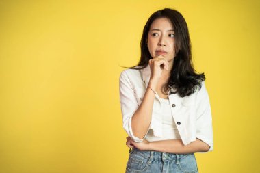 Asyalı kadın bir şey düşünüyor ve yukarı bakıyor.