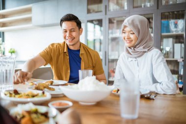 Arkadaşlar geleneksel yemeklerle birlikte yemek yerken eğleniyorlar.