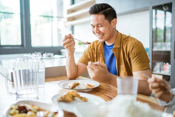 Ásia masculino ter almoço sentado no jantar mesa — Fotografia de Stock