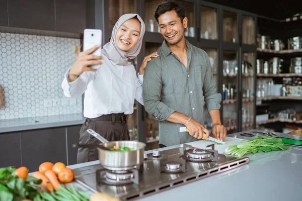 Jovem casal muçulmano com hijab tomando selfie juntos — Fotografia de Stock