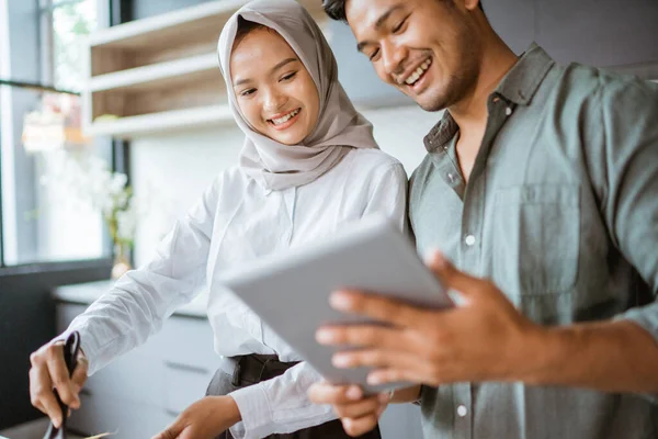 Muslimska par matlagning tillsammans i köket medan titta på video — Stockfoto