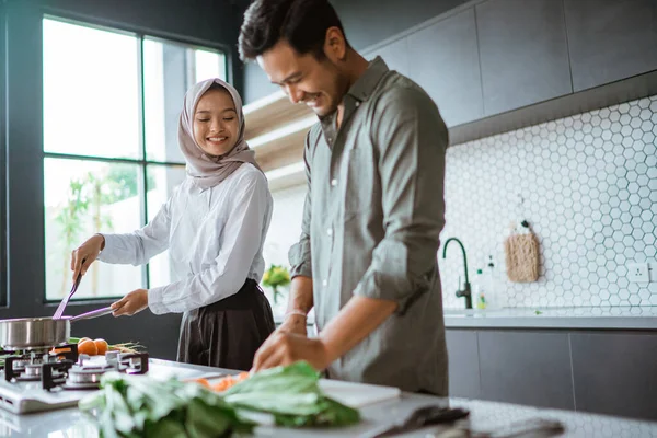 Романтична молода мусульманська пара отримує задоволення від приготування їжі вдома — стокове фото