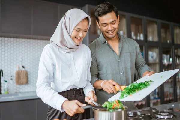Красива молода мусульманська пара готує разом — стокове фото