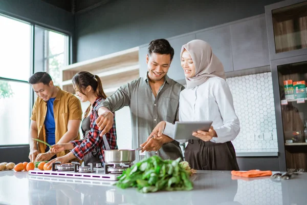 Vriend koken samen in de keuken terwijl kijken naar online cursus van tablet pc — Stockfoto