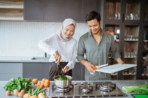 Романтическая молодая мусульманская пара получайте удовольствие от приготовления пищи дома — стоковое фото