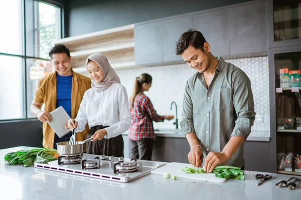 Tiro de um grupo de amigos cozinhar na cozinha juntos — Fotografia de Stock