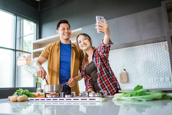 Aziatische paar het nemen van selfie terwijl samen koken in de keuken — Stockfoto