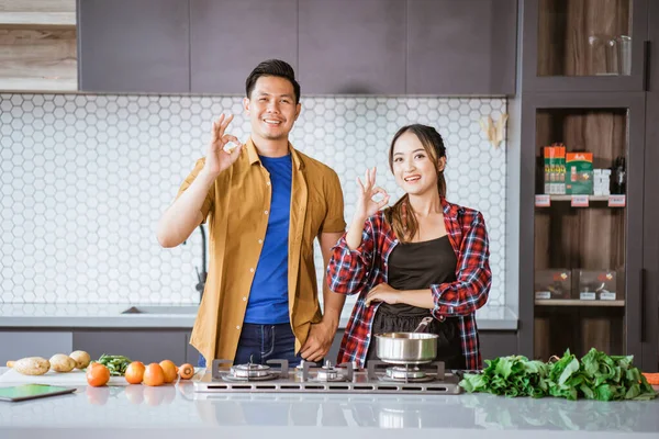 Casal se preparando para cozinhar na cozinha juntos mostrando polegar para cima — Fotografia de Stock