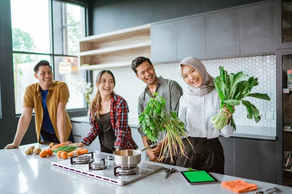 Foto van een groep vrienden die samen in de keuken koken — Stockfoto