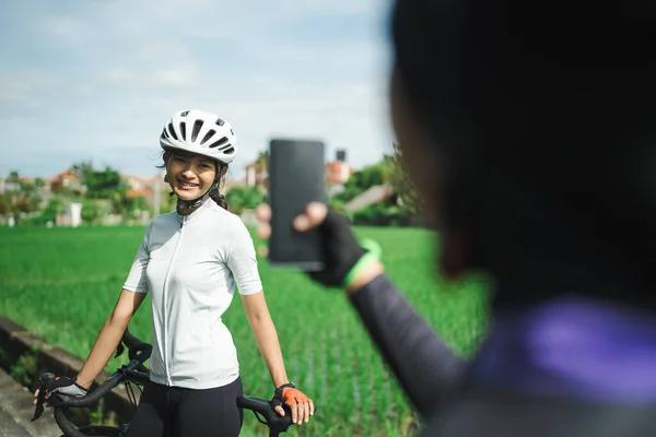 Ciclista tomando fotos en el hermoso paisaje mientras monta su bicicleta — Foto de Stock