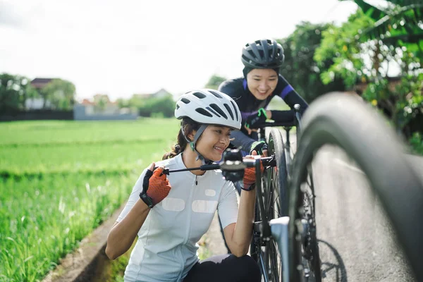 Asijský cyklista pomocí kapesní čerpadlo čerpadlo její kolo ploché pneumatiky — Stock fotografie