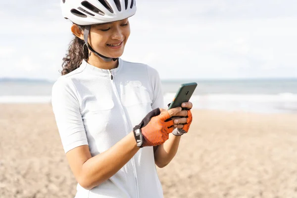 自転車に乗ってスマートフォンを見ている女性サイクリストは — ストック写真