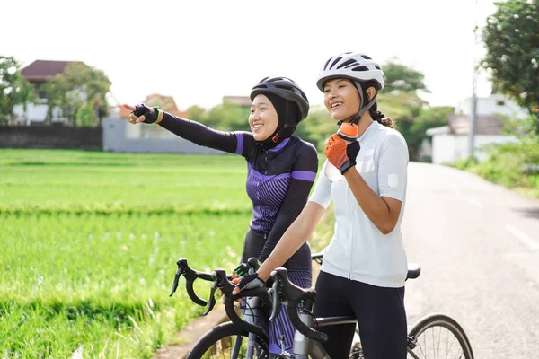 自転車の女性は道路脇に水を1本持っていて — ストック写真