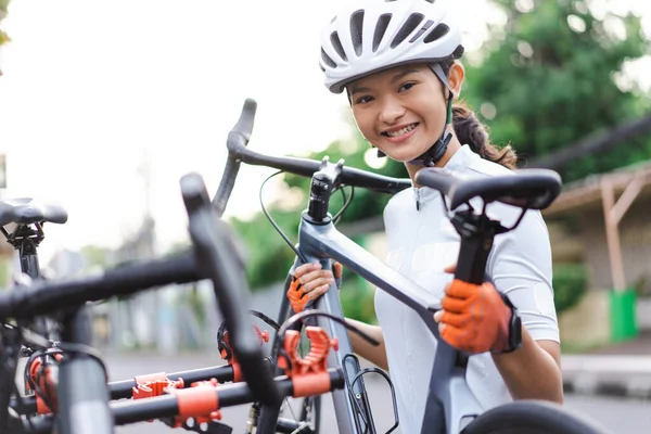 Ciclista mujer descargando su bicicleta de carretera en un bastidor en la parte posterior de su coche — Foto de Stock