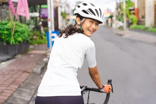 Žena cyklistka na koni její kolo ve městě střílet zezadu — Stock fotografie