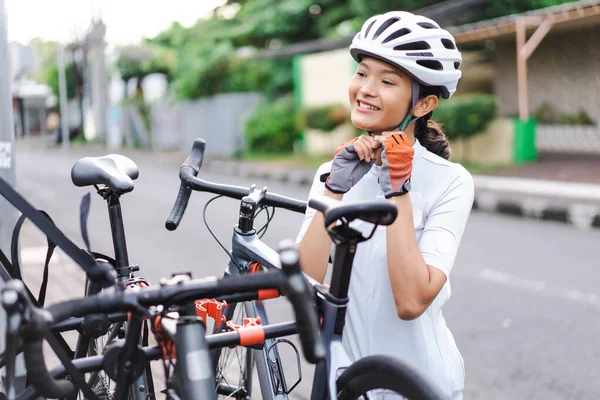 Ciclista mujer con su casco deportivo al aire libre en la mañana con bicicleta de carretera — Foto de Stock