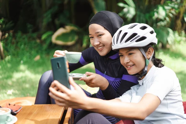 Beautiful cyclist take a break at coffee shop and taking photos together — Stock Photo, Image